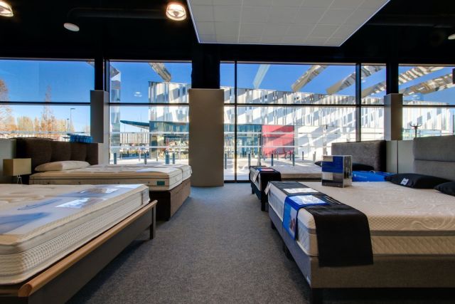 Photo de la vitrine intérieure du magasin vitaliterie présentant plusieurs matelas pour illustrer les mentions légales