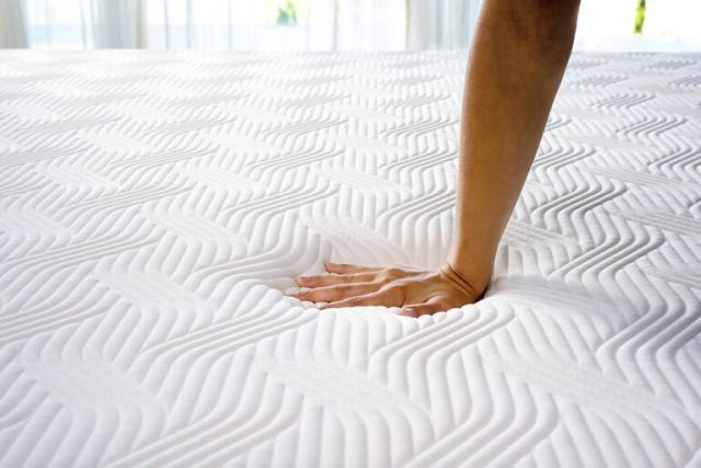 Photo d'une main qui s'appuie sur un matelas Tempur, marque partenaire de Vitaliterie