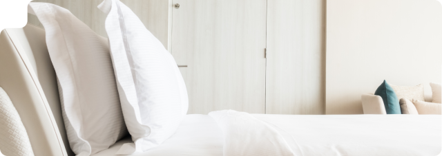 Photo d'un lit avec une couette et deux oreillers blancs pour illustrer l'article comment bien choisir son oreiller